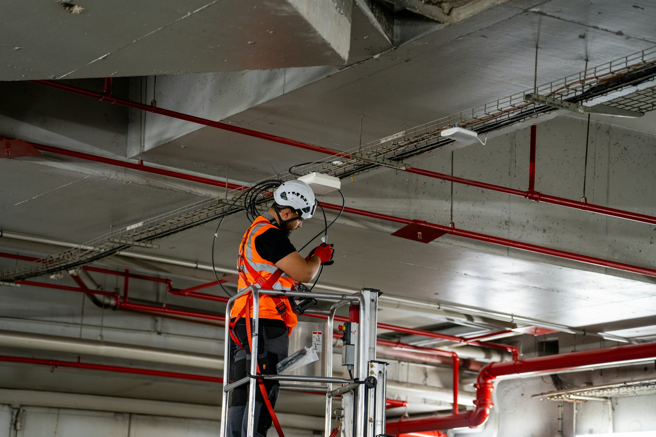 A fire protection technician working from a lift